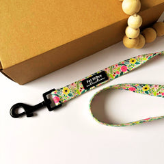 Top view of our Bloom Floral Dog Lead in pink roses and greenery print. Made from strong polyester webbing with inner padded neoprene handle for comfort. Featuring our sturdy metal swivel clip for tangle free walks. Available in Small (152cm x 1.5cm), Medium (152cm x 2cm), and Large (152cm x 2.5cm).