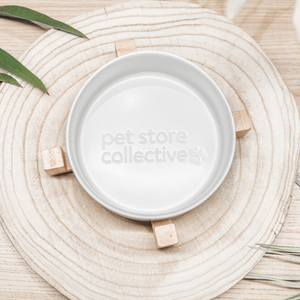 White Cloud Ceramic Pet Bowl with a bamboo base, measuring 19.5 cm in length and 9 cm in height. This durable bowl holds 3.6 cups (850 ml) and features high edges to minimise spills. Dishwasher-safe for easy cleaning, it has a crisp white finish with a natural bamboo base and an embossed Pet Store Collective logo inside the bottom of our ceramic bowl.