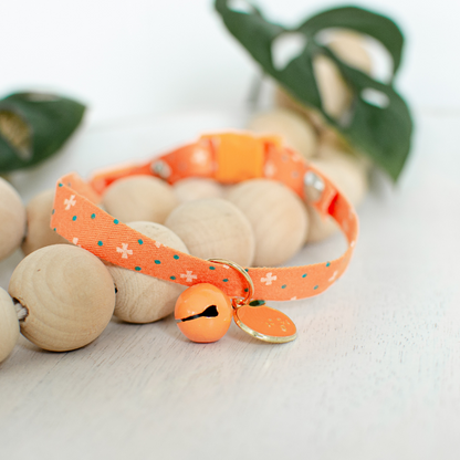 Orange cat collar with fruit charm and matching bell, designed for both charm and safety, crafted from hypoallergenic materials with bells and quick-release buckles. Available in sizes from Extra Small (15-20CM) for cats weighing up to 2kg to Small (20-30CM) for cats weighing 2-6kg, ensuring a perfect fit for most cats.