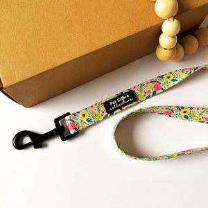 Top view of our Bloom Floral Dog Lead in pink roses and greenery print. Made from strong polyester webbing with inner padded neoprene handle for comfort. Featuring our sturdy metal swivel clip for tangle free walks. Available in Small (152cm x 1.5cm), Medium (152cm x 2cm), and Large (152cm x 2.5cm).