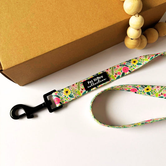 Top view of our Bloom Floral Dog Lead in pink roses and greenery print. Made from strong polyester webbing with inner padded neoprene handle for comfort. Featuring our sturdy metal swivel clip for tangle free walks. Available in Small (152cm x 1.5cm), Medium (152cm x 2cm), and Large (152cm x 2.5cm).