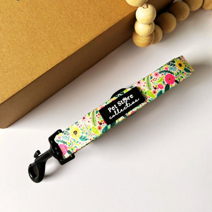 Angled top view of our Bloom Floral Dog Lead featuring soft greenery and pink rose pattern. Crafted from durable polyester webbing with a comfortable padded neoprene handle and a metal swivel clip for worry-free, tangle-free walks.