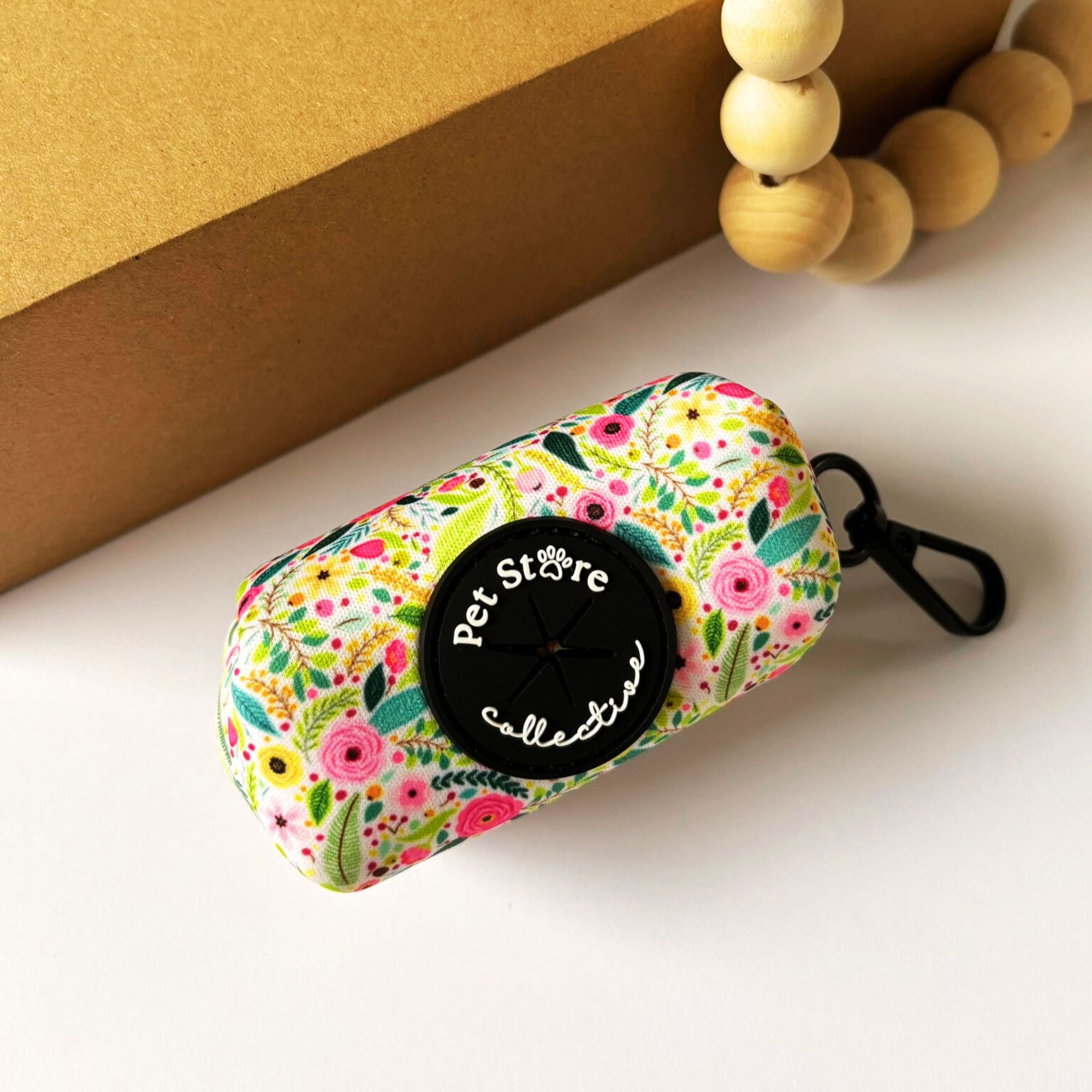 Top view of our Bloom Floral Dog Poop Bag Holder. Our stunning blooming pink roses and greenery design on neoprene, with metal clip for easy attachment to your dog's leads.