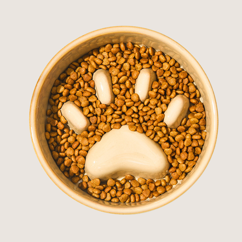 Brown Colour With Pet Food In The Bowl: Ceramic slow feeder dog bowl with charming paw print pattern and elevated wooden base, promoting comfortable and hygienic feeding. Durable, anti-slip, and resistant to chipping for lasting use. Elevate mealtime with style and functionality. Dishwasher safe for easy cleaning.