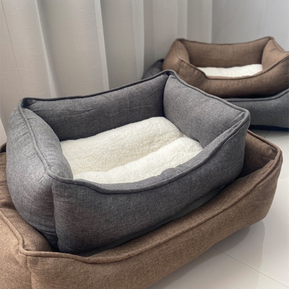 Our collection includes two sleek pet beds in timeless grey and brown: size small in brown and grey, and both a large grey and a large brown bed are featured. Each bed has elevated edges, soft cotton lining, and an anti-slip base for extra comfort and stability.