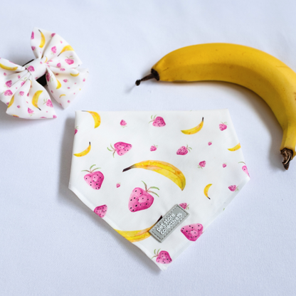 Exclusive design by Pet Store Collective: Limited-edition tropical fruit bandana and bow tie set (S/M, 25-47cm neck size, bow tie L 9cm x H 6cm), featuring bananas and strawberries, set against a white background, suitable for small-to-medium pets.