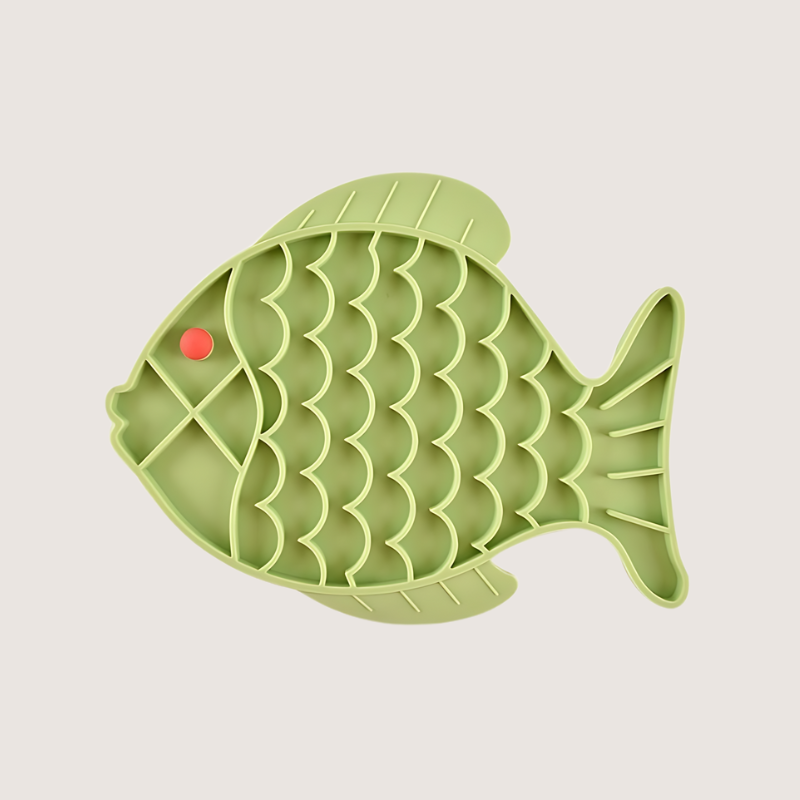 Green fish-shaped silicone lick mat measuring 19CM x 24.5CM, crafted from food-grade, BPA-free silicone. Freezer and dishwasher safe, helps promote healthy eating by slowing mealtime.