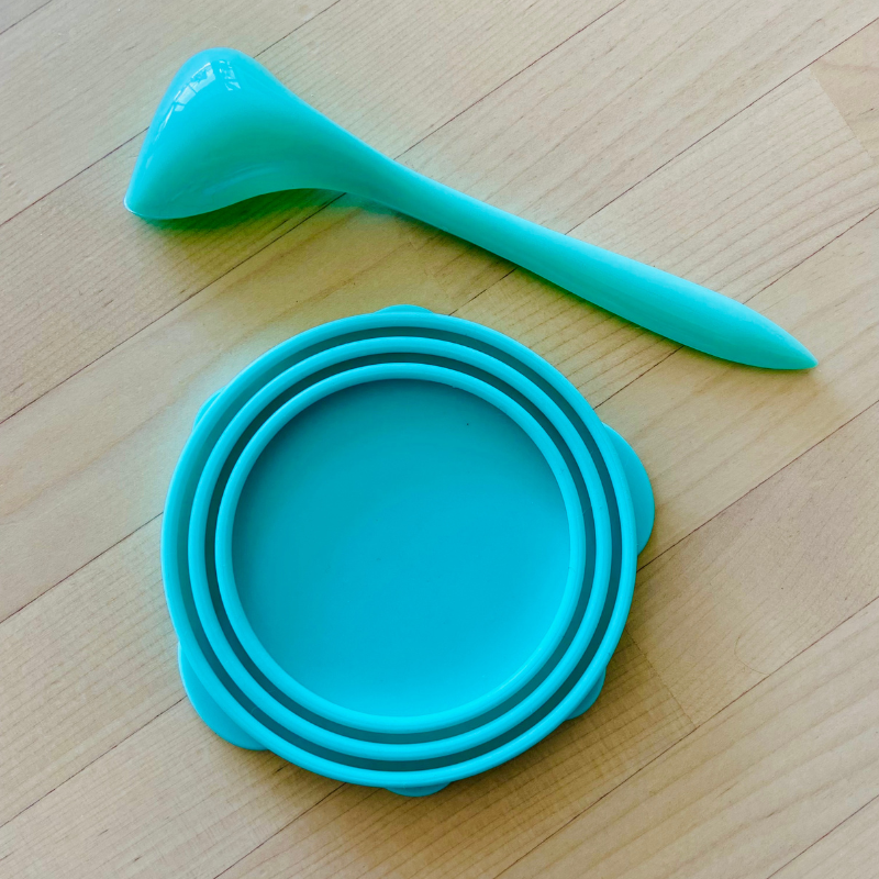 Close-up of green silicone paw can cover showing the three-ring layered design, crafted from food-grade silicone, leak-resistant, compatible with various round canned pet foods.