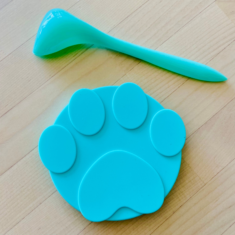 Green silicone paw can cover and spoon set, crafted from food-grade silicone, prolongs freshness, leak-resistant, dishwasher safe, features three-ring layered design, fits various round canned pet foods.