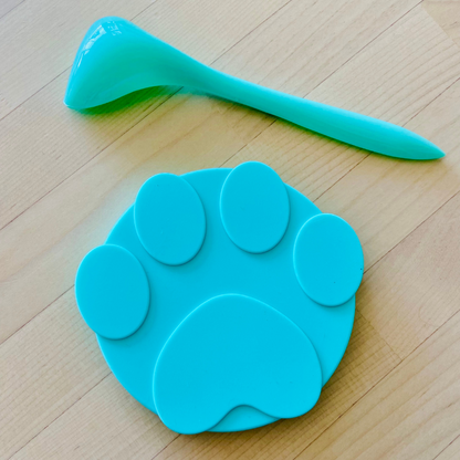Green silicone paw can cover and spoon set, crafted from food-grade silicone, prolongs freshness, leak-resistant, dishwasher safe, features three-ring layered design, fits various round canned pet foods.