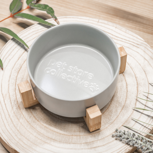 Our Silver Mist Ceramic Pet Bowl with a bamboo base, measuring 19.5 cm in length and 9 cm in height. This durable bowl has a 3.6 cup (850 ml) capacity and features high edges to minimise spills. Dishwasher-safe for easy cleaning, it boasts a sleek silver mist finish and an embossed Pet Store Collective logo inside the bottom, adding a modern touch to any home.