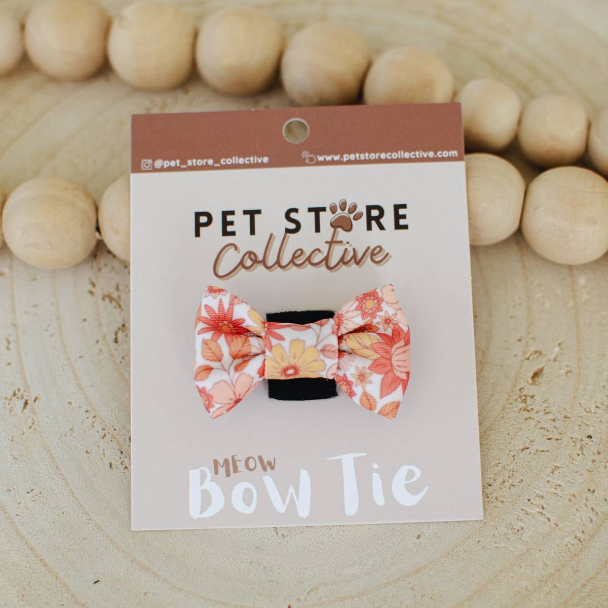 Our wildflower print cat bow tie in earthy tones, displayed with custom Pet Store Collective packaging. Lightweight 4.5 cm x 3 cm design with velcro backing for easy attachment.