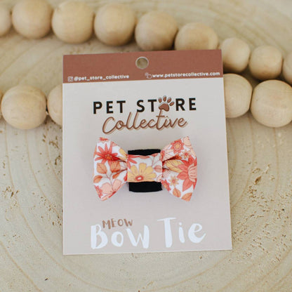 Our wildflower print cat bow tie in earthy tones, displayed with custom Pet Store Collective packaging. Lightweight 4.5 cm x 3 cm design with velcro backing for easy attachment.