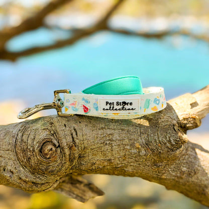 Close-up of our limited release Summer Bliss Dog Lead showing the Pet Store Collective logo, beach-inspired print. Featuring timeless silver hardware, with anti-tangle design. Crafted with durable polyester webbing and a cloud-soft neoprene handle for comfy summer walks.