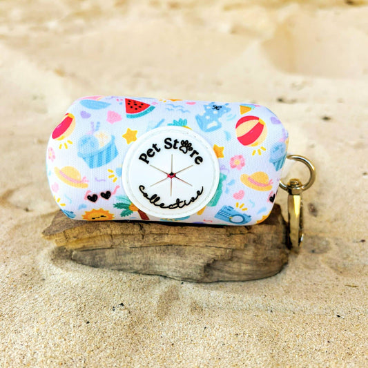 Front view of our Summer Bliss dog poop bag holder featuring our beach print with palm trees and sunny icons. Crafted from durable quick-dry neoprene with a custom Pet Store Collective rubber dispenser, with secure zipper holder for one standard roll of waste bags.