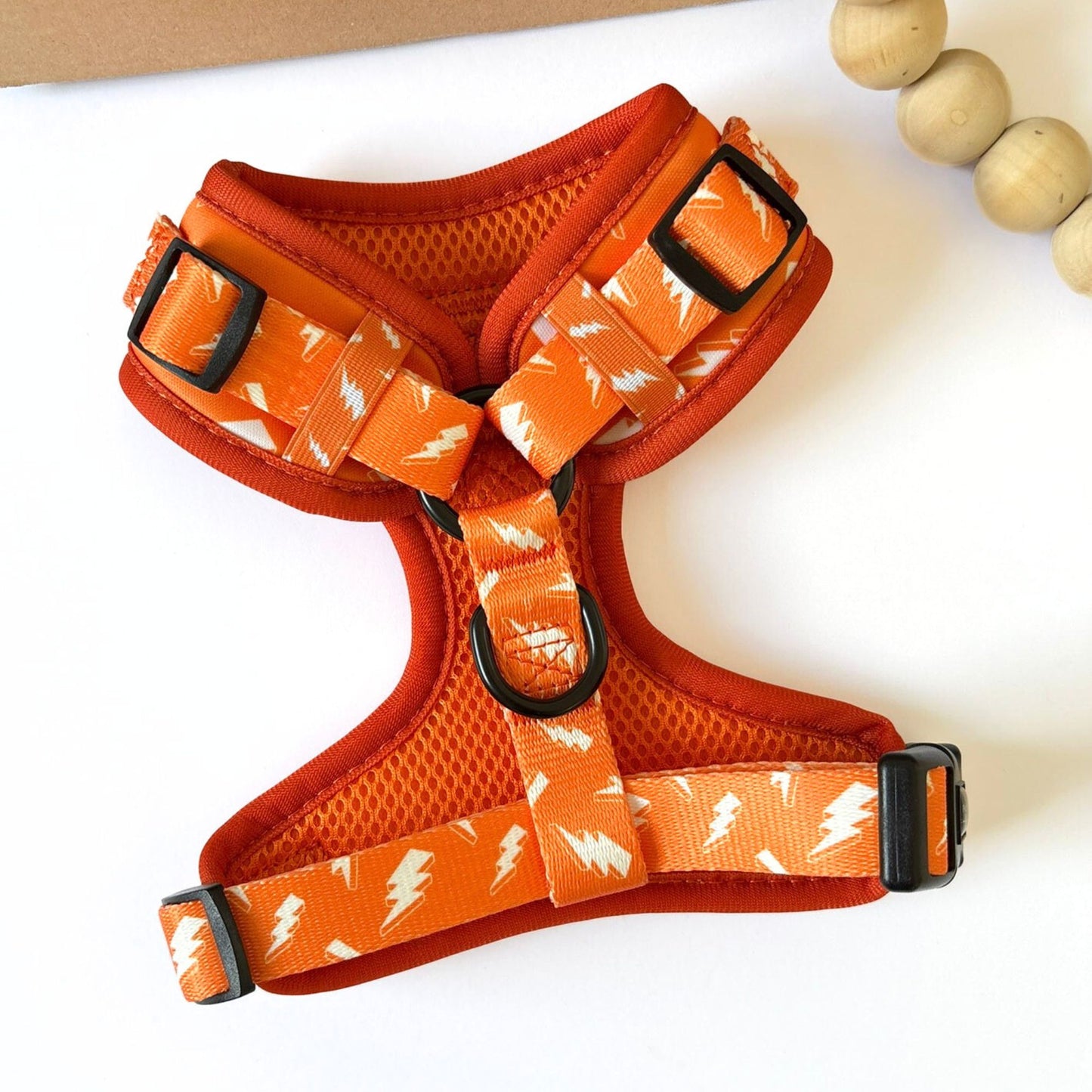 Back view of our Thunderbolt Adjustable Dog Harness in orange with white thunderbolt design, featuring fully adjustable straps, lightweight mesh, and durable buckles for dogs and cats.