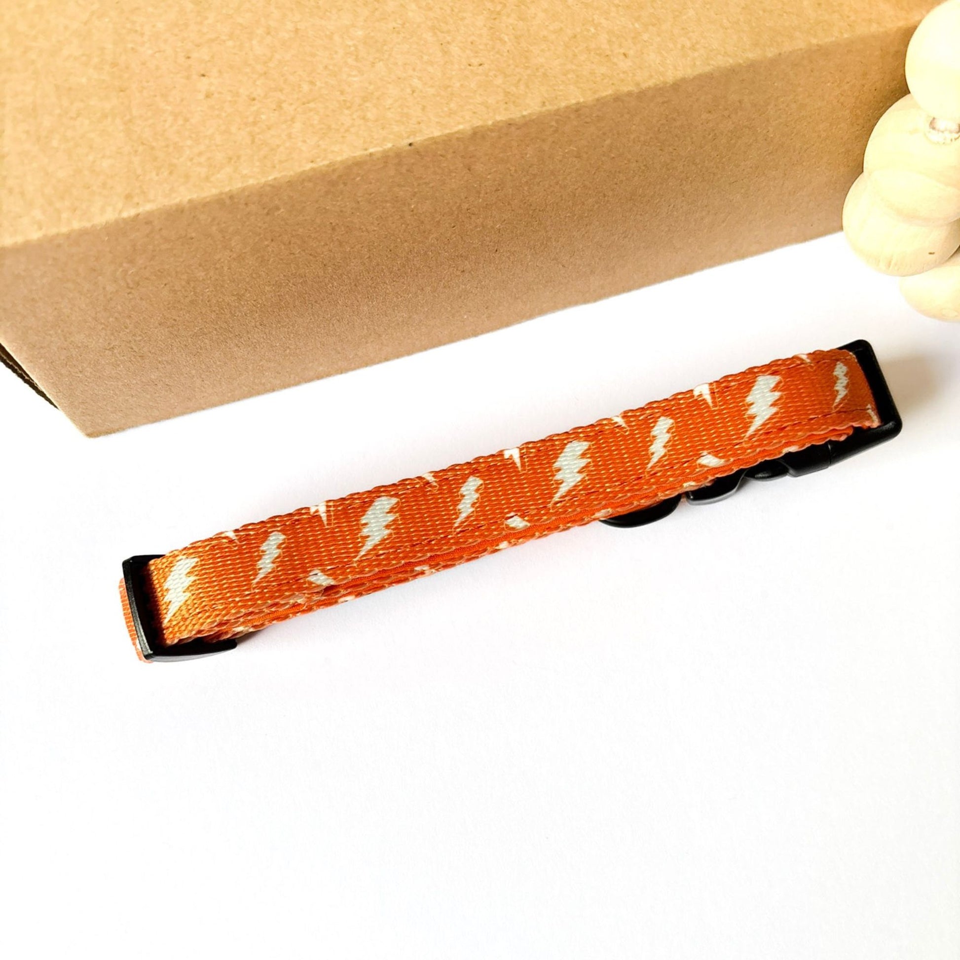 Back view of Thunderbolt Dog Collar in orange with white thunderbolts. Fully adjustable strap, durable hardware and neoprene padding for comfort on dog walks.