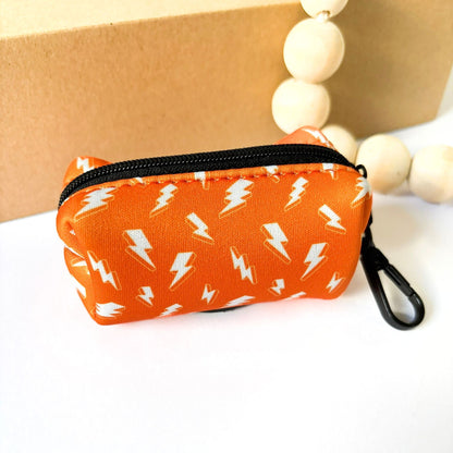 Back view of our Thunderbolt Dog Poop Bag Holder, featuring secure zipper holder in orange with white thunderbolt pattern. Weather-resistant neoprene design for carrying waste bags, keys, or small treats.