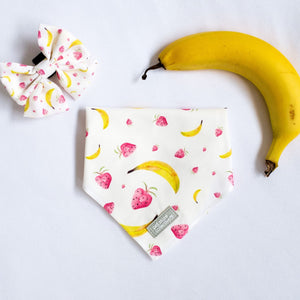 Top view of our Tropical Dog Bandana and Matching Sailor Bowtie in vibrant tropical fruit print, designed for cats and dogs, displayed with a fresh banana for a fun summer vibe.