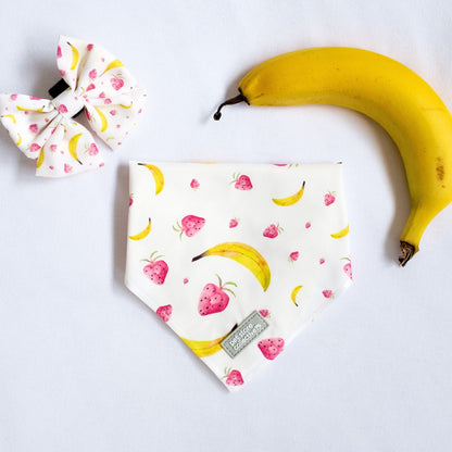 Top view of our Tropical Dog Bandana and Matching Sailor Bowtie in vibrant tropical fruit print, designed for cats and dogs, displayed with a fresh banana for a fun summer vibe.