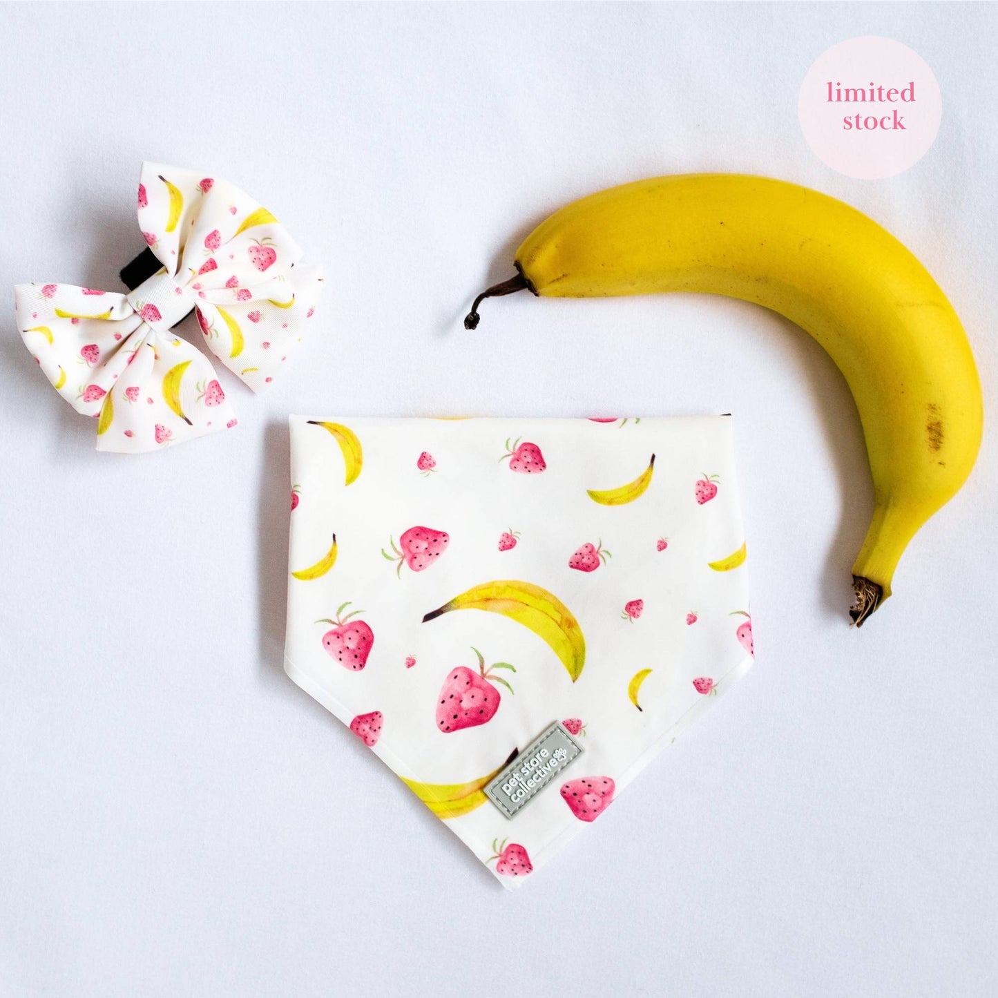 Top view of our Tropical Dog Bandana and Matching Sailor Bowtie in vibrant tropical fruit print, designed for cats and dogs, displayed with a fresh banana for a fun summer vibe.