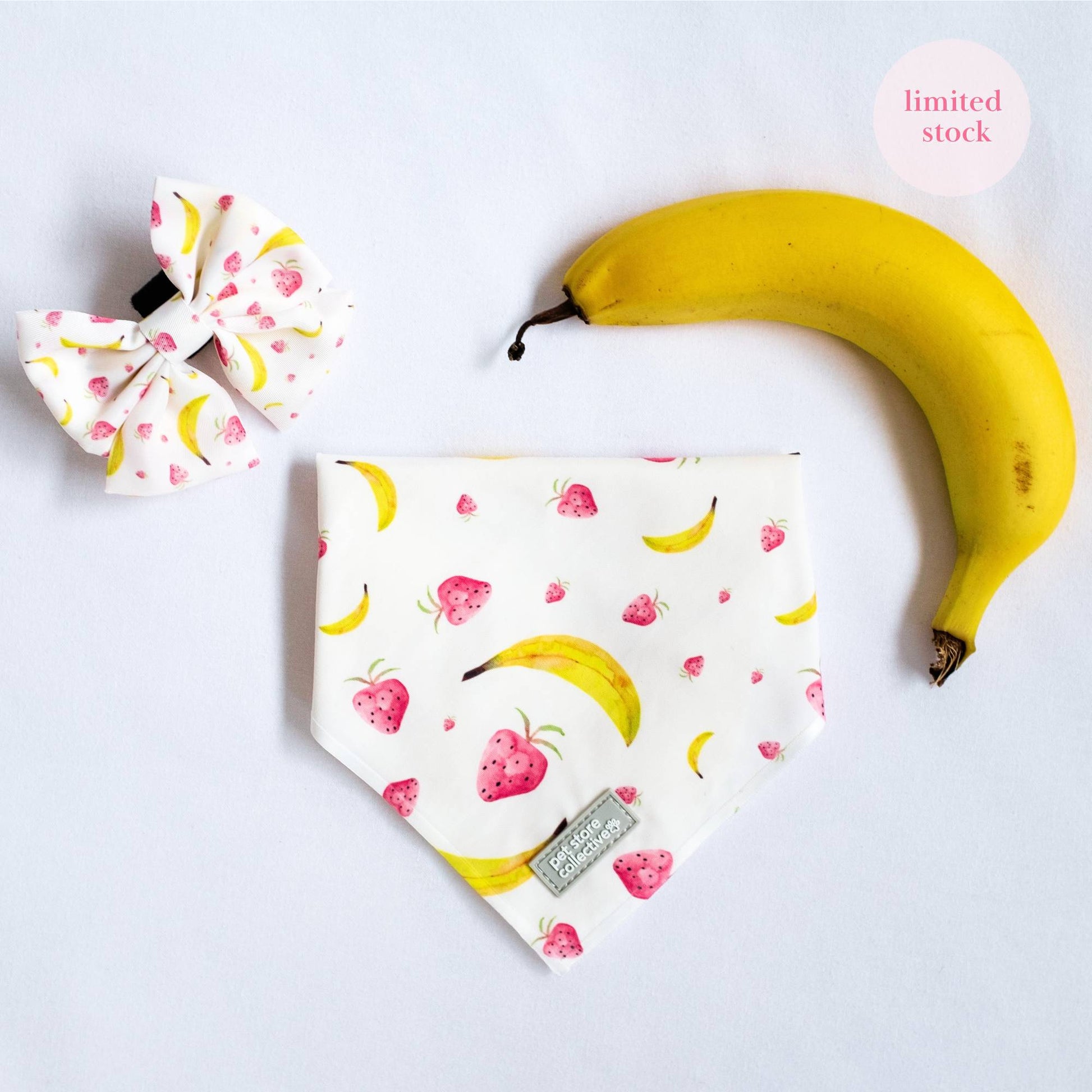 Top view of our Tropical Dog Bandana and Matching Sailor Bowtie in vibrant tropical fruit print, designed for cats and dogs, displayed with a fresh banana for a fun summer vibe.