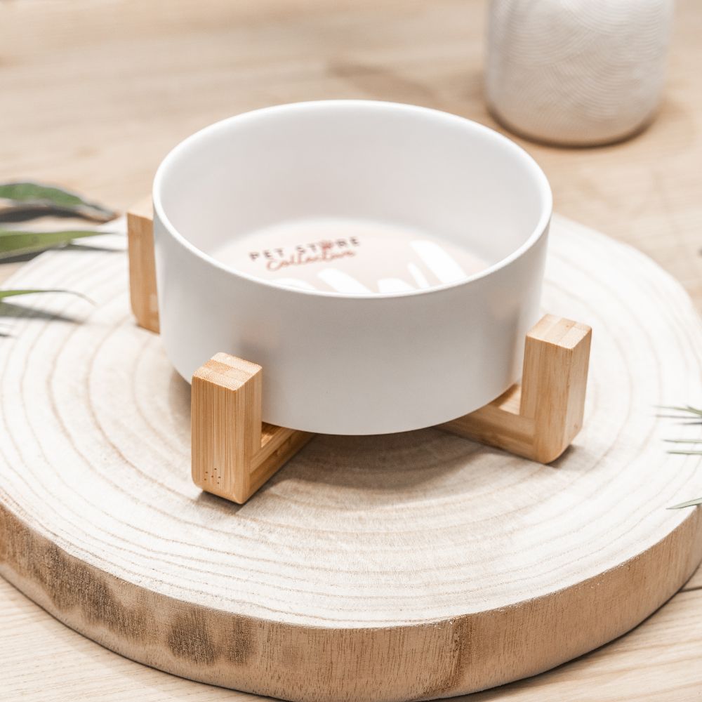 White ceramic pet bowl side view with bamboo stand on wooden board by Pet Store Collective.